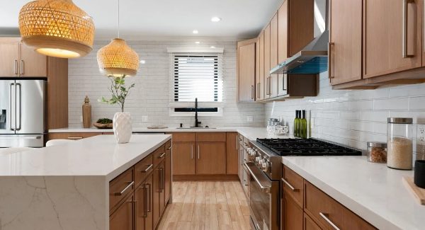 Large kitchen with warm wood cabinets and white countertops with matte nickel hardware.